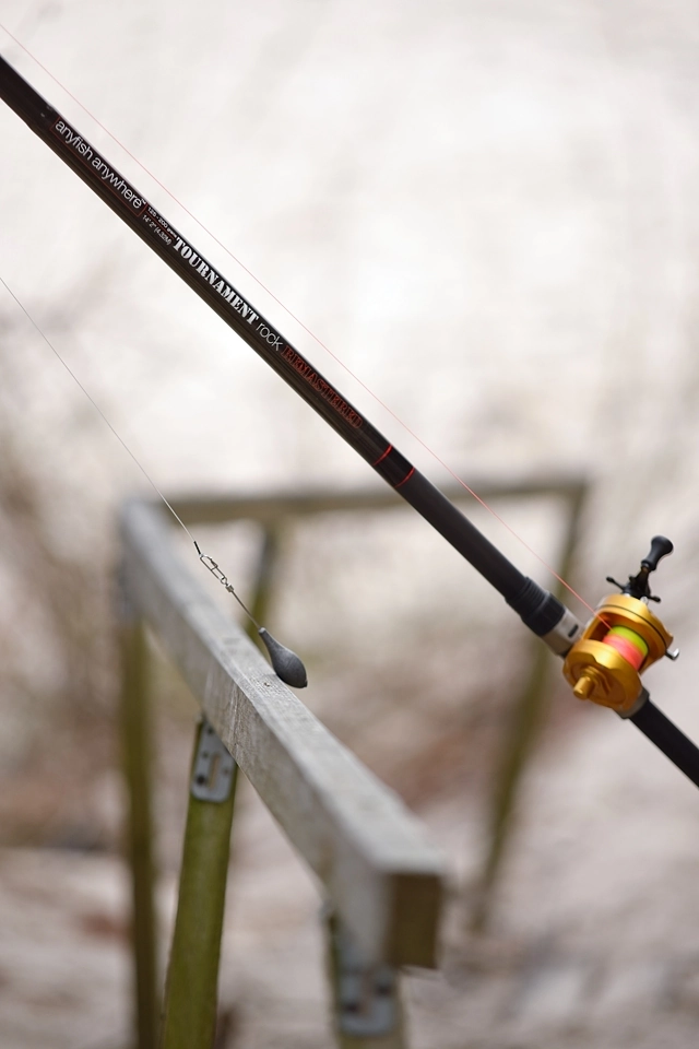 Wędka oparta o poręcz barierki zejścia na plażę w Sarbinowie