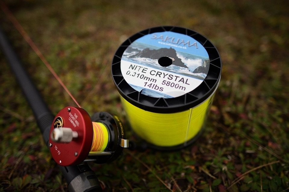 Duża szpula żyłki obok wędki z kołowrotkiem